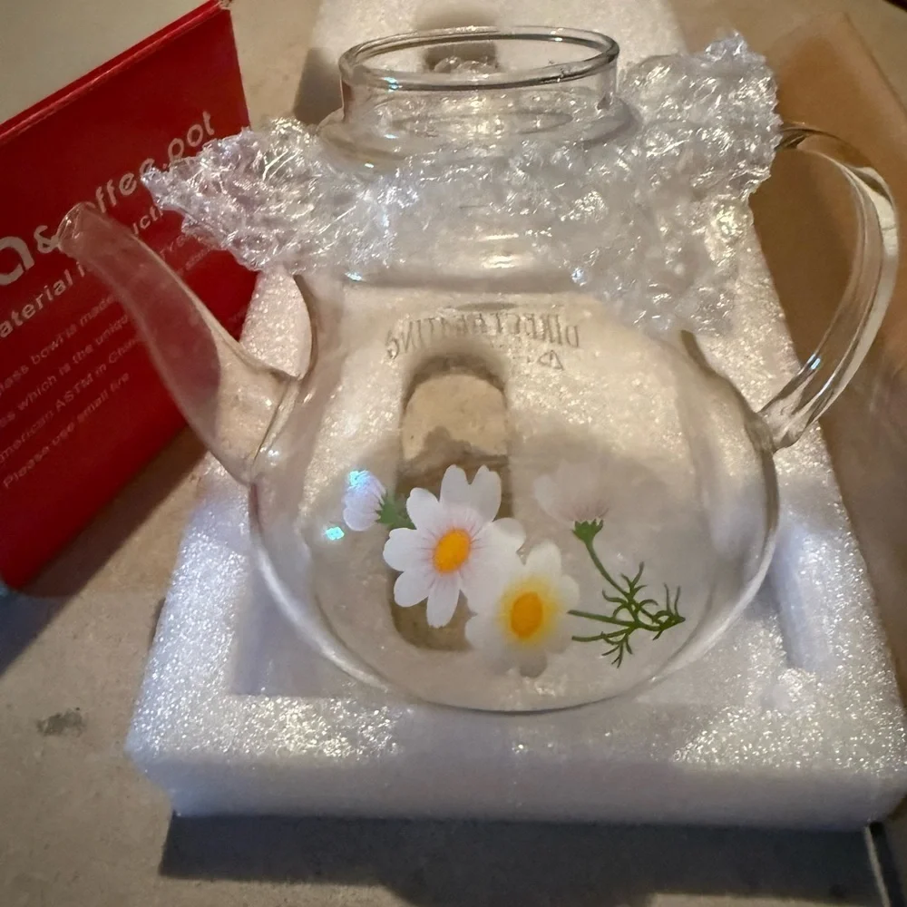 Glass tea pot about 6 inches tall including the lid has decorative yellow flower